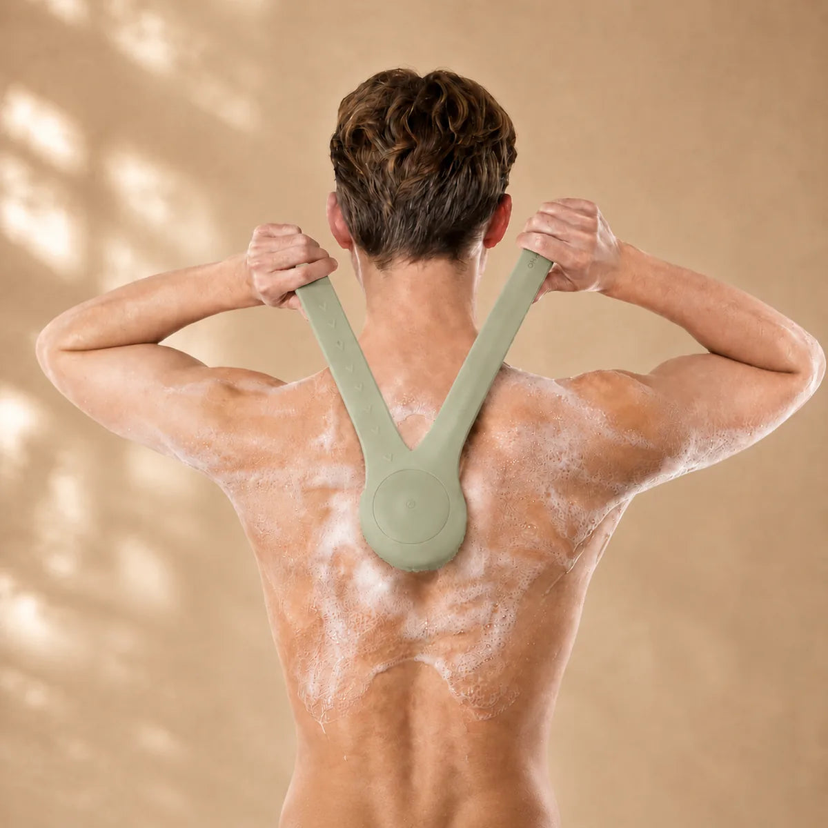 BodyGlow Brush utilisée pour atteindre le dos et les trapèzes sous la douche